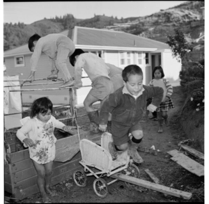 Young Maori children playing, and a Maori man holding a young girl, all at Stokes Valley