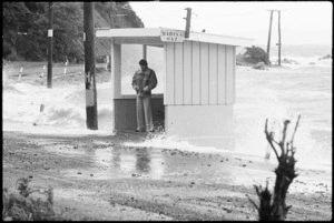 Man standing at a bus stop during a storm, Mahina Bay, Eastbourne