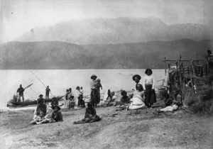 Burton Brothers 1868-1898:Photograph of a group of people sitting on the shore of Lake Tarawera