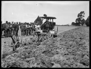 Ploughing a field using a disc harrow hauled by a tractor, probably Canterbury region