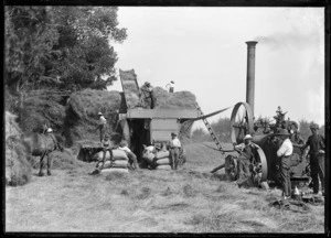 Farm labourers working a threshing machine