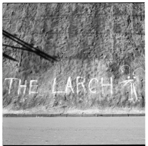 "The Larch" graffiti, and, men relaxing in the sun, Wellington, 1974.