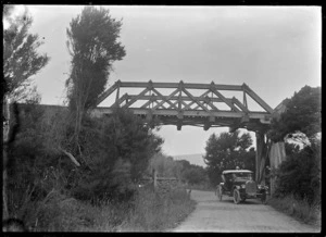 A chevrolet motor car parked below a railway bridge across the Waitati to Seacliff Road.