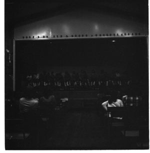 School performance of Polynesian dance in a school hall, possibly St Mary's College, and, inside a pub, probably the Railway Hotel, Wellington