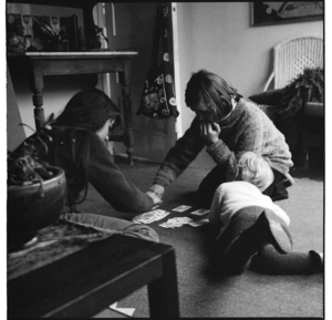 Children playing cards on the floor, and, adolescent girls