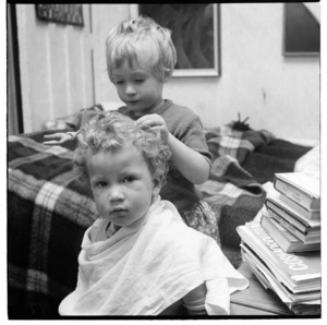 Two small children play-acting as hairdressers