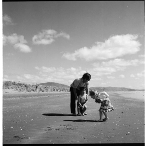 Children and a man playing on a beach, possibly at Raumati