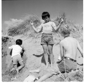 Family playing in sand dunes, possibly at Raumati Beach