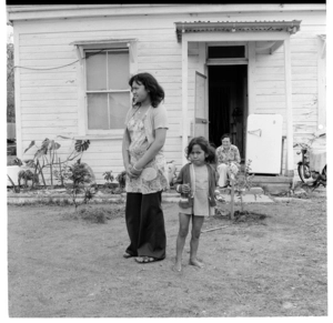 Young Māori family outside their home