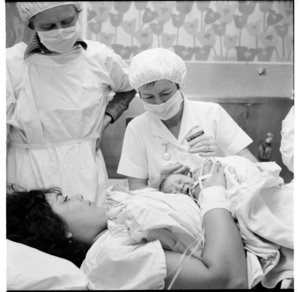 Photographs in a hospital, a woman with her newly-born baby