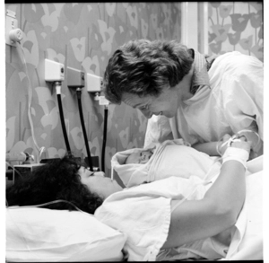 Photographs in a hospital, a woman with her newly-born baby