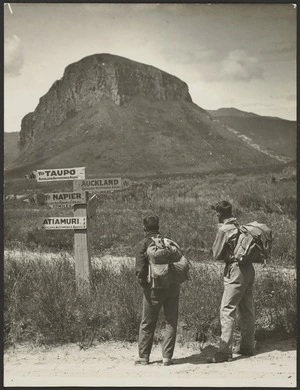 Two men standing by signpost, Atiamuri