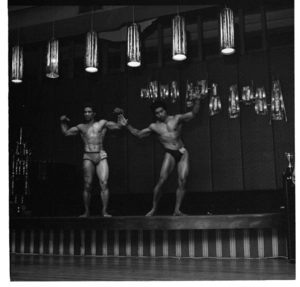 Men at a bodybuilding competition, posing on stage at an undentified venue in Porirua