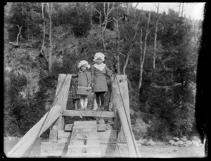 Portrait of two girls standing on a bridge