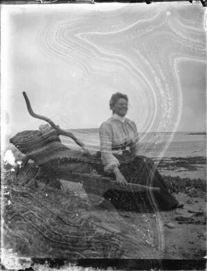 Woman seated on shore