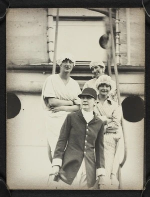 Four women in fancy dress aboard a ship