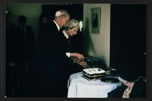 Lady Agnes Isobel Stout and Sir Thomas Duncan Macgregor Stout cutting their Golden Wedding Anniversary cake, Wellington Botanic Gardens