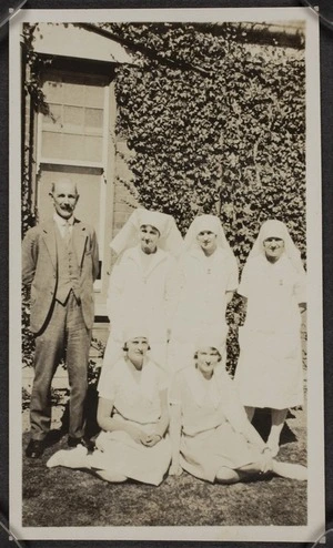 Thomas Duncan McGregor Stout with nurses outside an ivy covered building, during World War Two