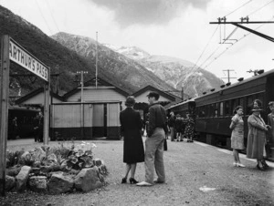 A view of Arthur's Pass Railway Station showing a train and passengers on the platform