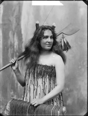 Studio portrait of a young woman wearing traditional Maori clothing - Photographed by William Henry Thoas Partington