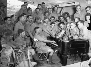 Soldiers singing around a piano at the YMCA in Maadi, Egypt, during World War II