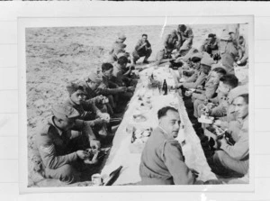 Members of the 28 (Maori) Battalion eating Christmas Dinner in the desert, Nofilia, Libya - Photograph taken by Dr C N D'Arcy