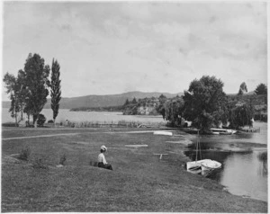 Woman sitting beside Lake Taupo at the mouth of the Waikato River