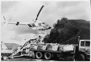 Bell helicopter hovering over fertiliser truck