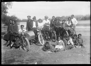 Creator unknown :Photograph of group with motorcyles on the shoreline of an unidentified river