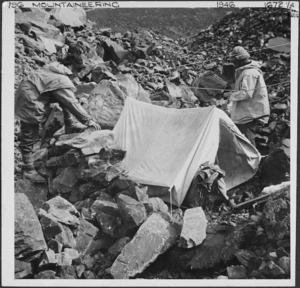 Mountaineers securing tent in rocky valley