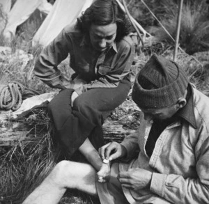Bill Davidson performing first aid on Kath Boswell's foot during tramping expedition in Kaikoura Ranges