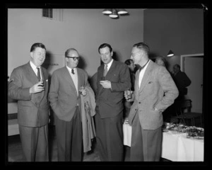 Unidentified men with drinks beside a buffet at event [associated with Pan American World Airways (Pan Am) Polar Route flight?]
