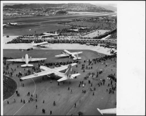 Helicopter view of the opening of Wellington Airport, showing crowds inspecting aeroplanes