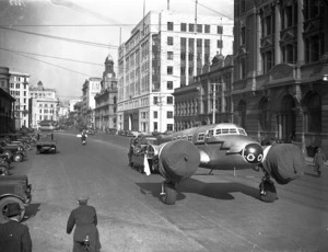 Lockheed Electra aeroplane being towed along Customhouse Quay, Wellington