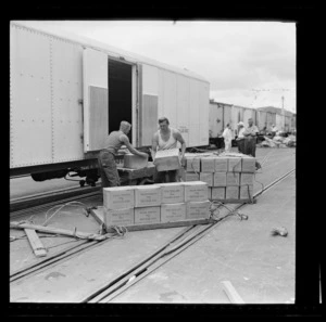 Men unloading butter from a railway wagon at Opua Wharf, Bay of Islands, Far North District, Northland Region