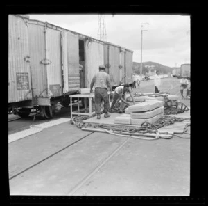 Men unloading beef from a railway wagon at Opua Wharf, Bay of Islands, Far North District, Northland Region