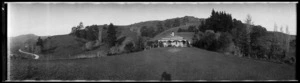 Wooden house and grounds at the foot of a hill, in the Nelson area