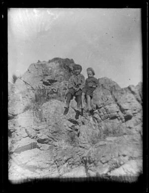 Children seated on rock outcrop