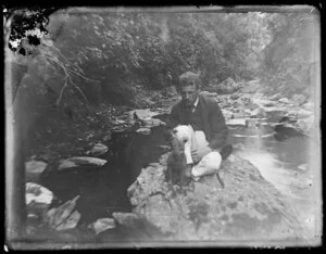 Man on rocks beside stream