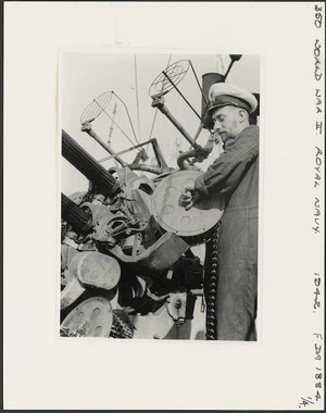 Officer placing drum of ammunition in anti-aircraft gun on board HMS Leander, Egypt