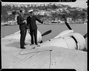 Mr Dobson interviewing TEAL Chief Engineer G V Brann on the wing of a Solent seaplane, Evans Bay, Wellington - Photograph taken by E Woollett