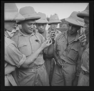 Group around a soldier from the 28th New Zealand (Maori) Battalion displaying an Iron Cross, Egypt