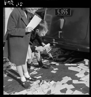 Children picking up paper on Lambton Quay, Wellington, on the day before VE day