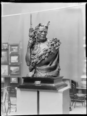 Sculpture of a Maori man labelled 'The Chieftain', by Trethewey,in an unidentified art gallery