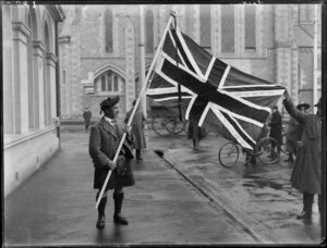 Mr Lauder with a Union Jack, outside Christchurch Cathedral