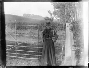 Woman standing by farm gate