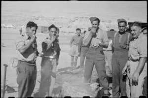 Members of the 28th (Maori) Battalion eating hangi-cooked potatoes on Christmas Day, Egypt - Photograph taken by George Robert Bull