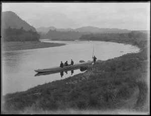 A canoe on a river with three passengers and steerer on bank with punting pole [Christchurch?]