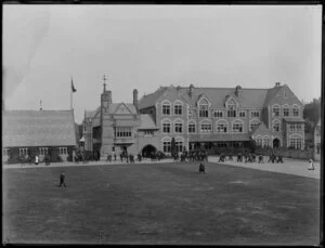 Quadrangle and buildings at Christ's College, Christchurch, including School House and Big School, with students and masters walking through grounds