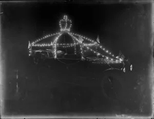 Car decorated with lights, crown and Union Jacks [royal visit?]